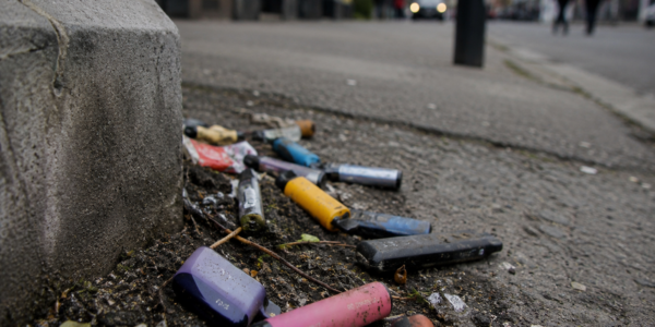 Vapes liegen weggeworfen in Straßenecke zwischen Dreck.