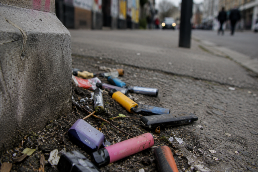 Vapes liegen weggeworfen in Straßenecke zwischen Dreck.